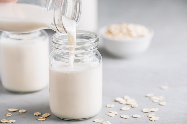 Oat Milk in glass Vegan non dairy oat milk on gray stone background copy space