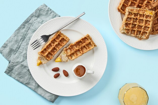 Oatmeal belgian waffles in pencil shape on blue table flat lay top view