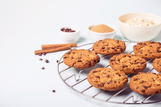 Oatmeal chocolate chip cookies on a round grate for cooling and ingredients