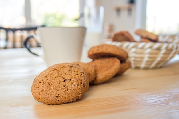 Oatmeal cookies and a cup of tea on a wooden table.