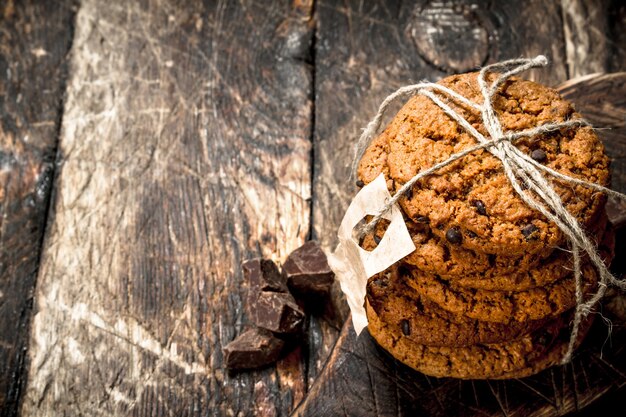 Oatmeal cookies with chocolate on a wooden background