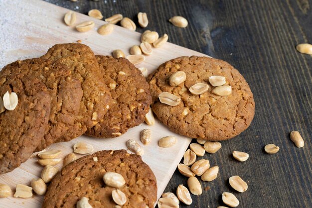 Oatmeal cookies with peanuts on a black wooden table