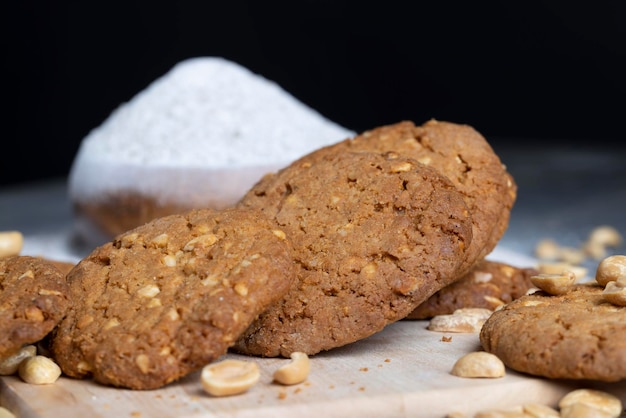 Oatmeal cookies with peanuts on a black wooden table