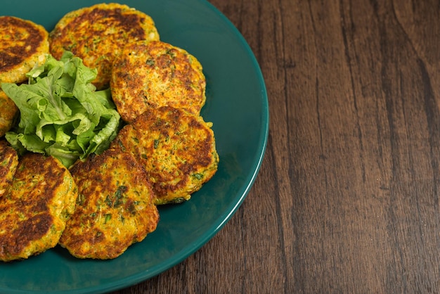 Oatmeal fritters with vegetables served on a plate on a wooden table Healthy food