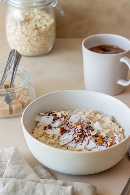 Oatmeal porridge with almonds, coconut and chocolate. Healthy eating. Vegetarian food. Breakfast. Diet.