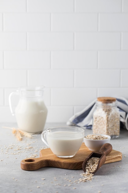 Oatmeal vegetable milk in a mug on the table with oatmeal in a bowl