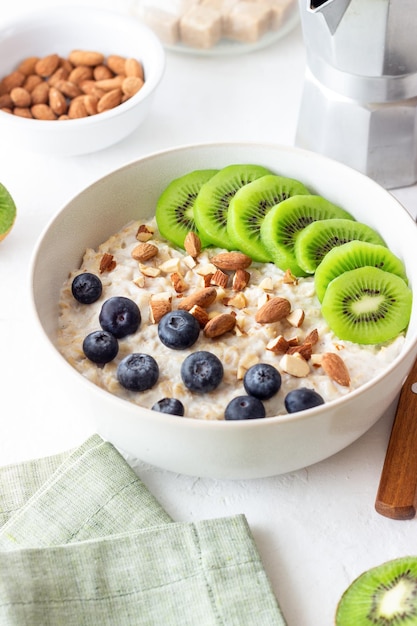 Oatmeal with kiwi blueberries almonds and honey Healthy food Vegetarian food Breakfast