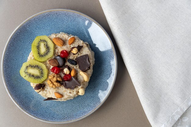 Oatmeal with nuts and chocolate on a blue plate. Proper nutrition.