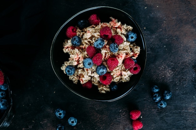 Oatmeal with raspberries and blueberries in a black plate