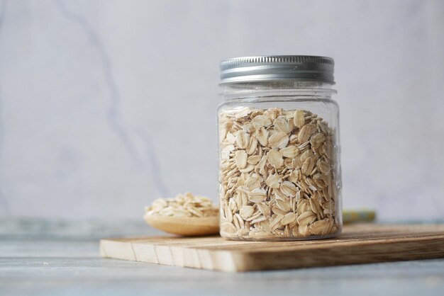 Oats flakes in a jar with spoon on table