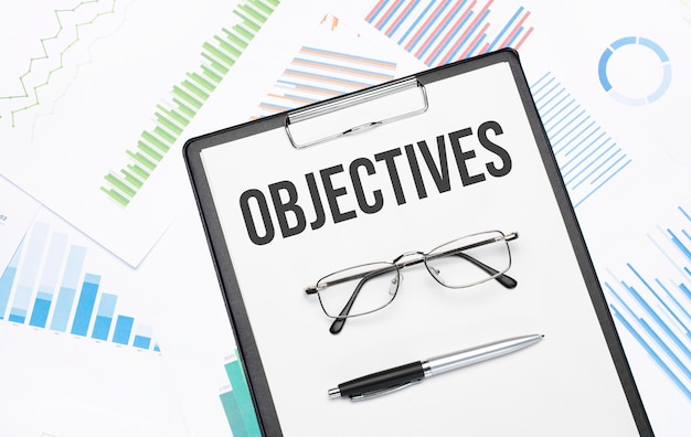 OBJECTIVES sign. Conceptual background with chart ,papers, pen and glasses