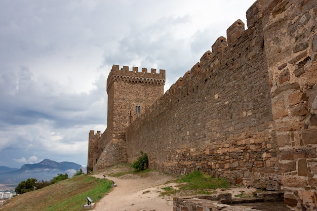 The observation tower of the fortress. A medieval fortress. View of the old stone fortress. The fortress wall.