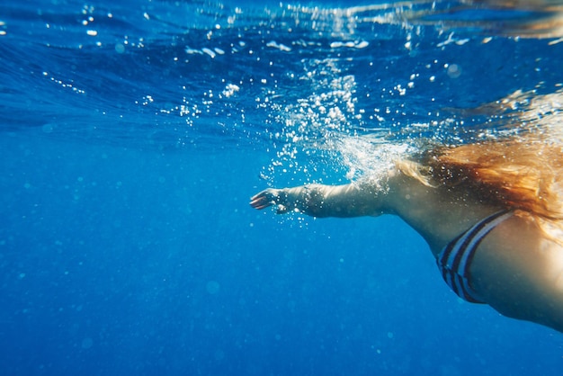 The ocean has what soothes my soul Shot of an unrecognisable woman swimming in the Mediterranean Sea in Italy