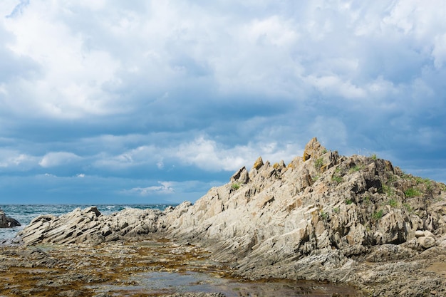 Ocean shore with rocks of columnar basalt Cape Stolbchaty on Kunashir Island