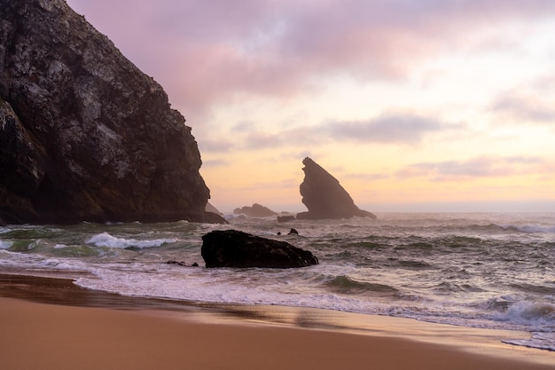 Ocean wild beach stormy weather Praia da Adraga sandy beach with picturesque landscape background Sintra Cascais Portugal