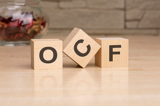 OCF acronym from wooden blocks with letters top view on grey background