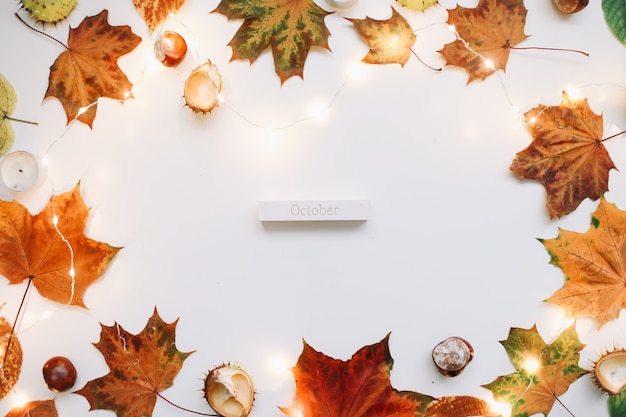 October flat lay and autumn composition with leaves candles and chestnuts top view