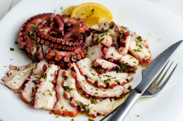 Octopus Carpaccio on white plate.