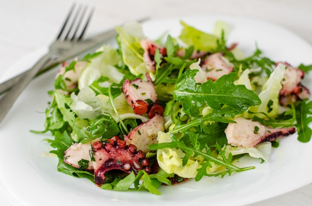 Octopus salad on white plate