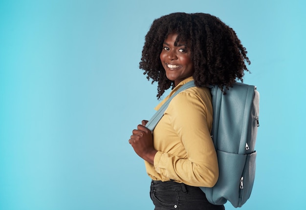 Off to secure my future be back soon Studio shot of an attractive young woman carrying a backpack against a blue background