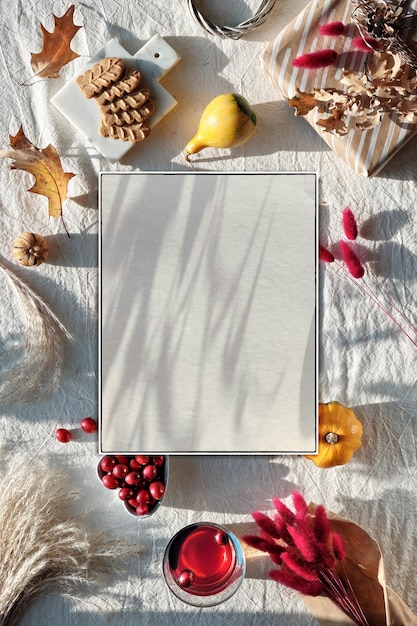 Off white mockup with shadows autumn decorations cranberry cookies tea and dry oak leaves and