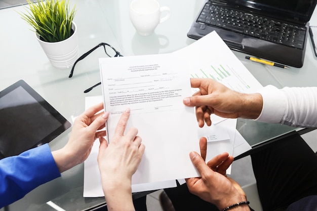 Office colleagues work with documents at the office table