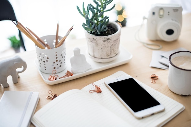 Office desk flat lay with coffe smartphone and succulents styl