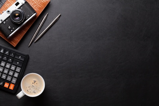 Office desk table with camera supplies and coffee