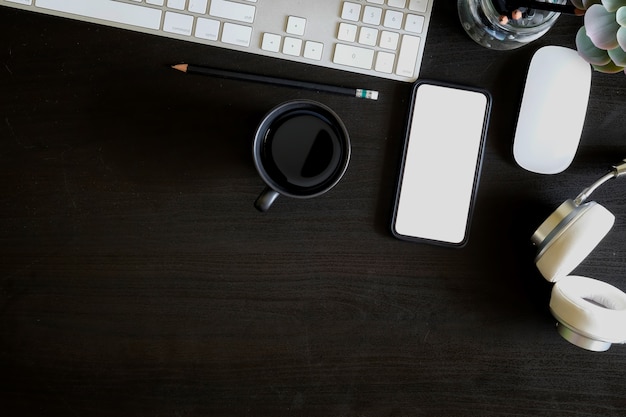 Office desk table with computer, mobile phone, supplies and coffee cup. 