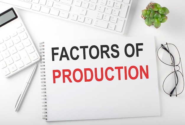 Office desk table with keyboard notepad and calculator Top view with text FACTORS PF PRODUCTIONS