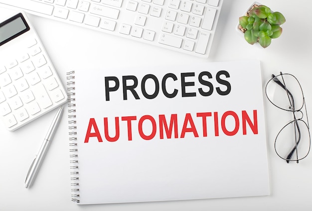 Office desk table with keyboard, notepad and calculator. Top view with text PROCESS AUTOMATION