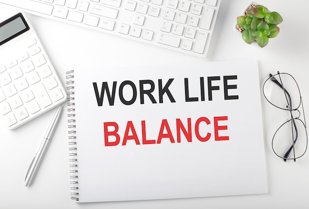 Office desk table with keyboard, notepad and calculator. Top view with text WORK LIFE BALANCE