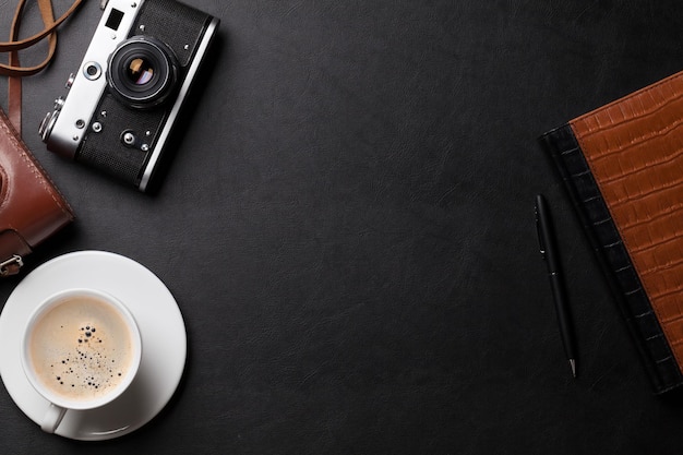 Office desk with camera coffee and notepad