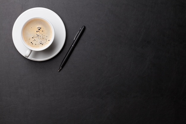 Office desk with coffee cup and pen