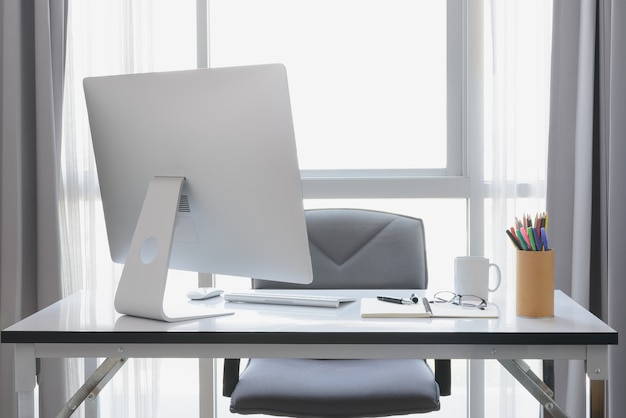 Office desk with desktop computer, cup of coffee and office equipment