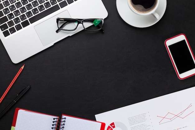 Office desk with laptop coffee notepad and phone