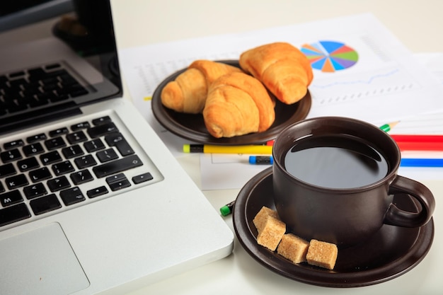 Office desk with laptop and a cup of coffee