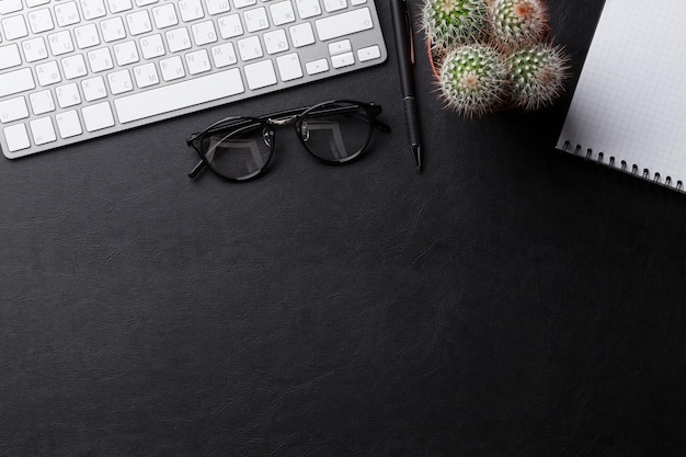 Office desk with pc notepad and cacrus