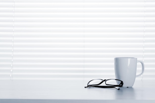 Office desk workplace with coffee cup and glasses