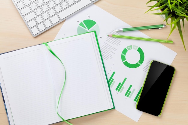 Office desk workplace with phone charts and notepad