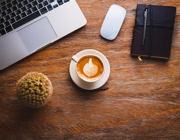 Photo office equipment with cup of coffee laptop and notebook are on the wooden table top view