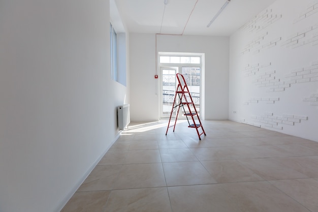 Office extension that uses bricks as a wall, construction, improvement. Interior of small room with window and bricks walls renovation, extension, overhaul and reconstruction.