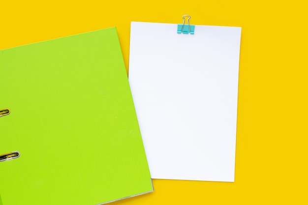 Office folder with papwer on yellow background. Top view