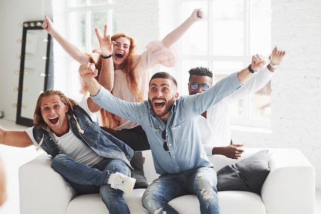 Office friends have cheerful time sitting and laying on the white sofa