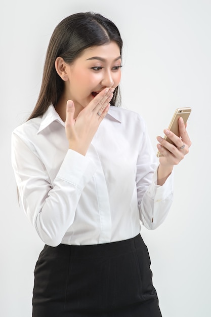 Office girl, online merchant is showing joy, shocked
When sales surpassed the target of mobile phones on white background. Business, online trading, presenter concept.