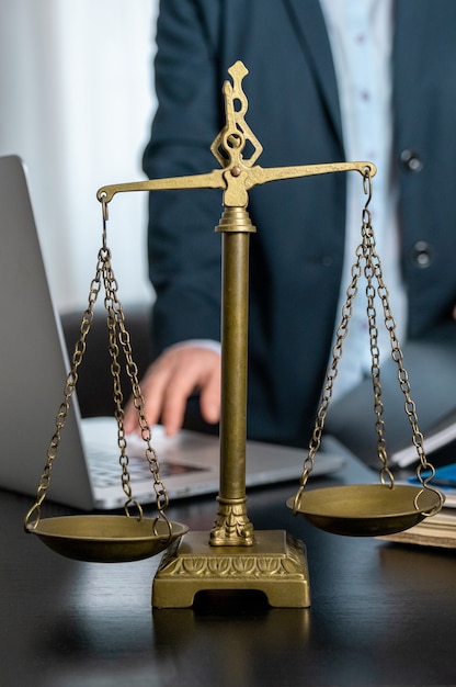 Office of Lawyer with Scales, laptop and documents on the workplace.