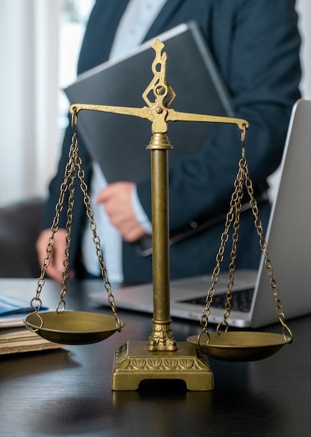 Office of Lawyer with Scales, laptop and documents on the workplace.