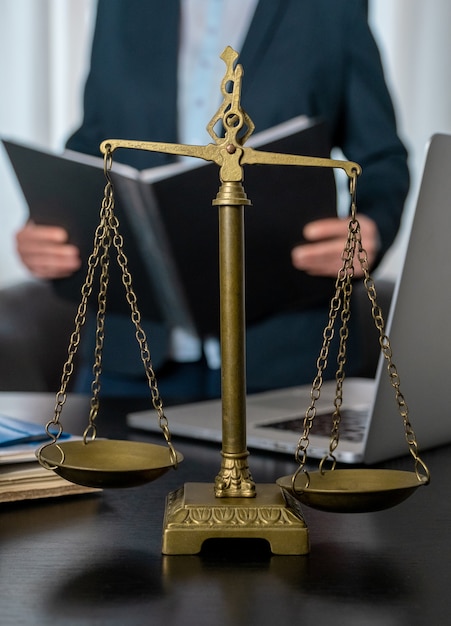 Office of Lawyer with Scales, laptop and documents on the workplace.