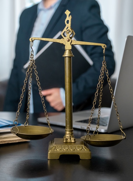 Office of Lawyer with Scales, laptop and documents on the workplace.