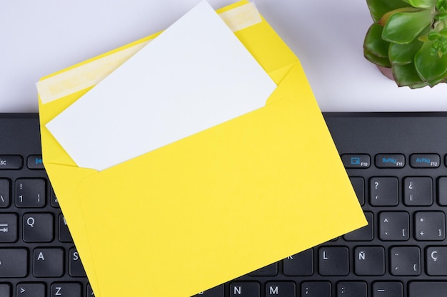 Office letter card invitation mock up template with white paper yellow envelope and keyboard